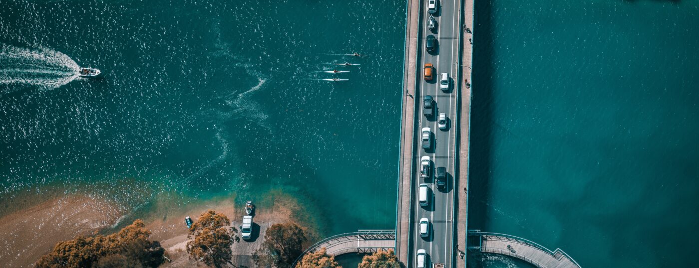 boats going under a crowded bridge